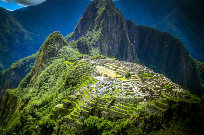 Starożytne ruiny Machu Picchu znajdowały się wśród bujnych, zielonych gór pod zachmurzonym niebem.